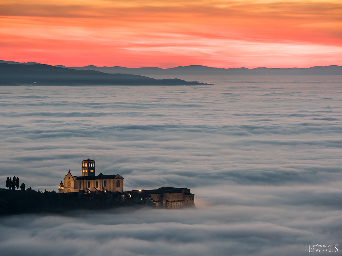 Assisi, Dicembre 2017. La Basilica di S.Francesco domina la Valle Umbra immersa in un mare di nebbia