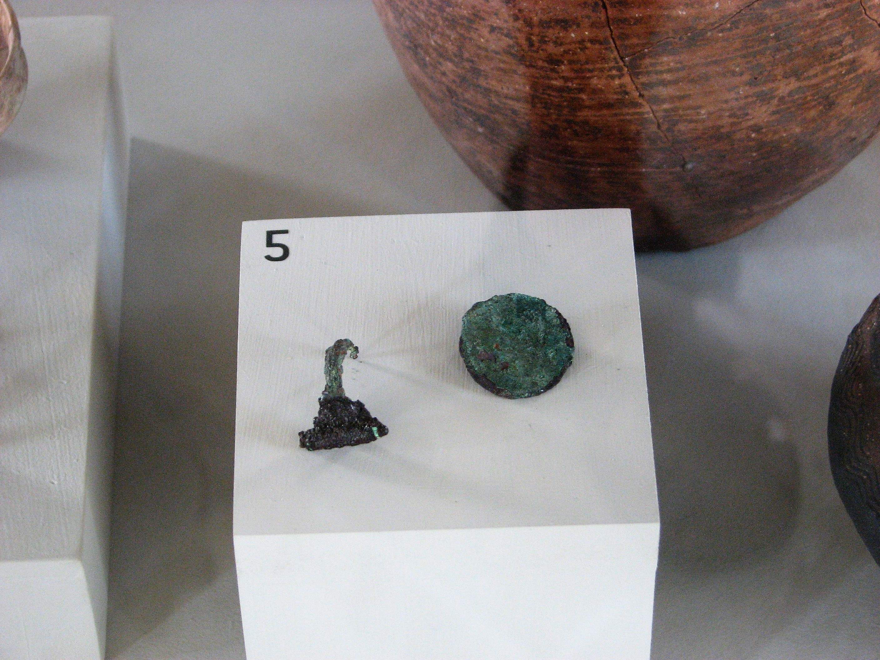Parte di mestolino in bronzo e asse dell'imperatore Domiziano