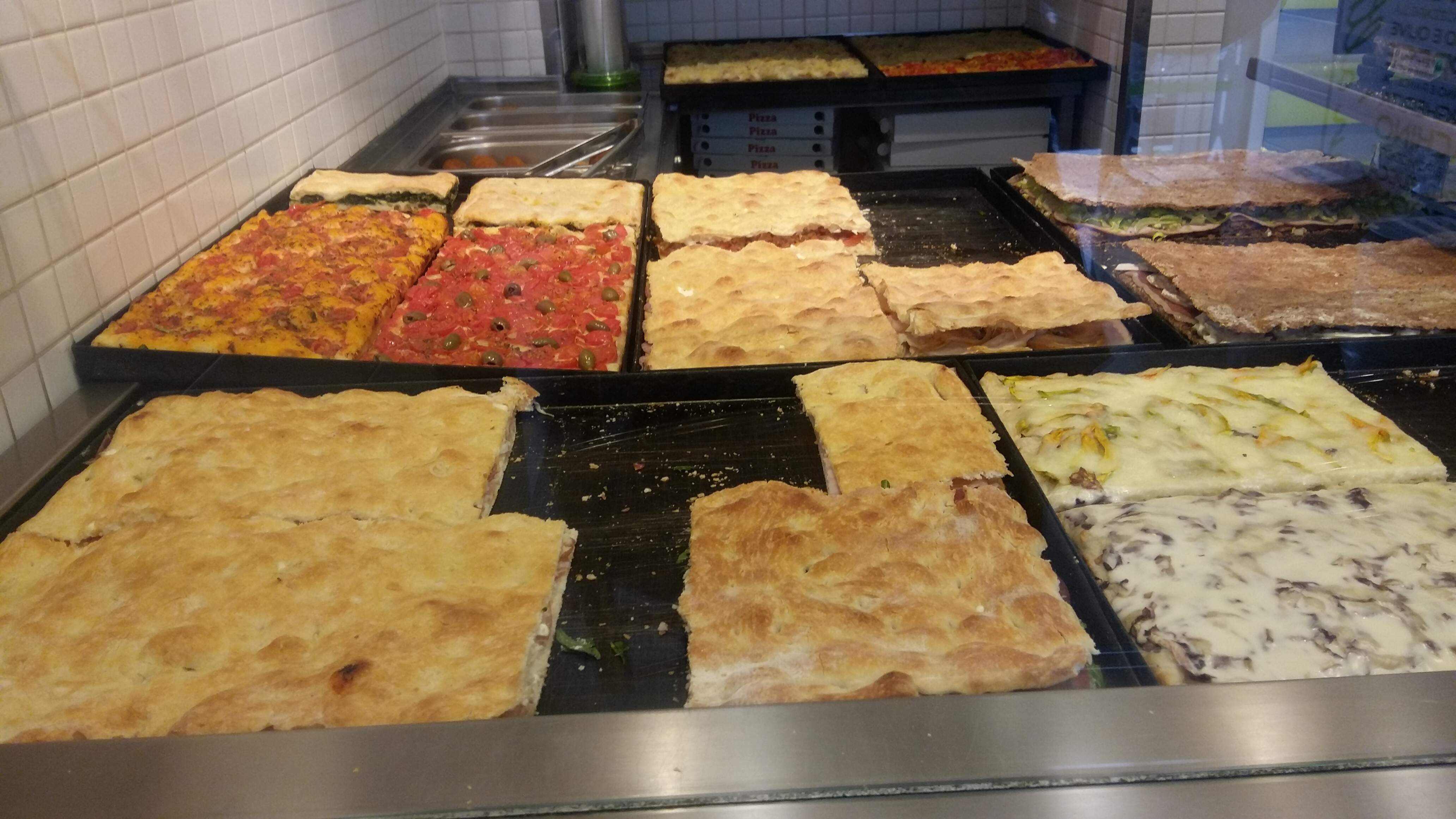 od lewej w glebi: focaggia foggiana, pizza z pomidorami i oliwkami, rozne pizze faszerowane