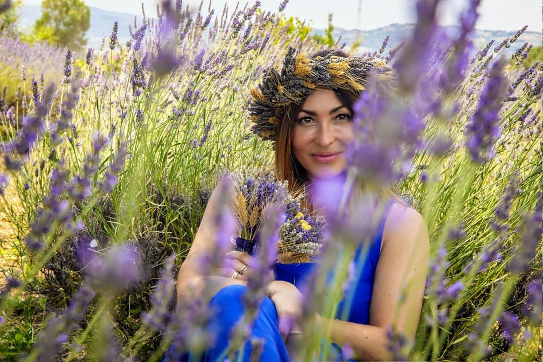 donna con corona di fiori e abito blu in un campo di lavanda, Umbria