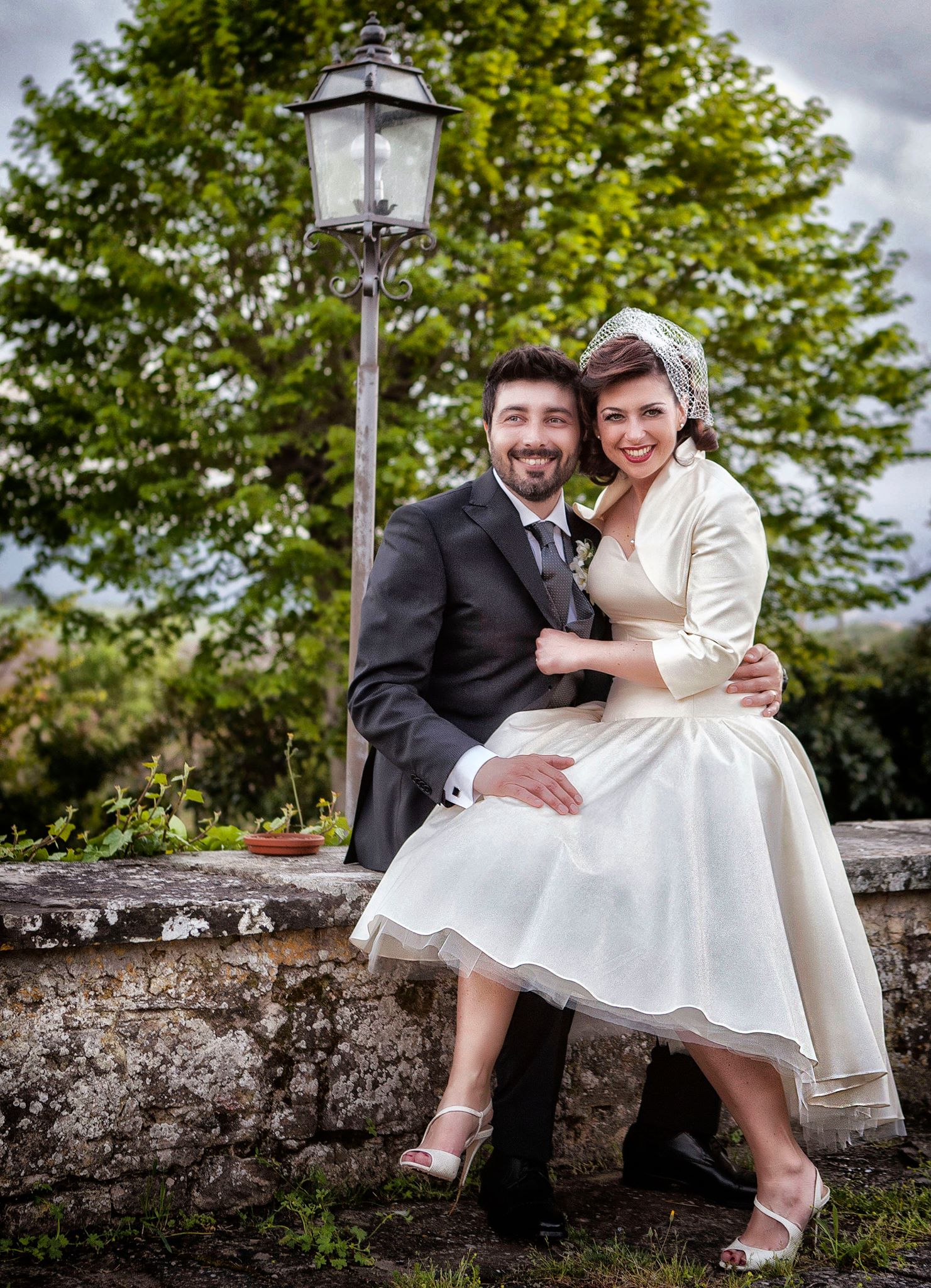 sposi felici seduti in giardino al ricevimento in Toscana