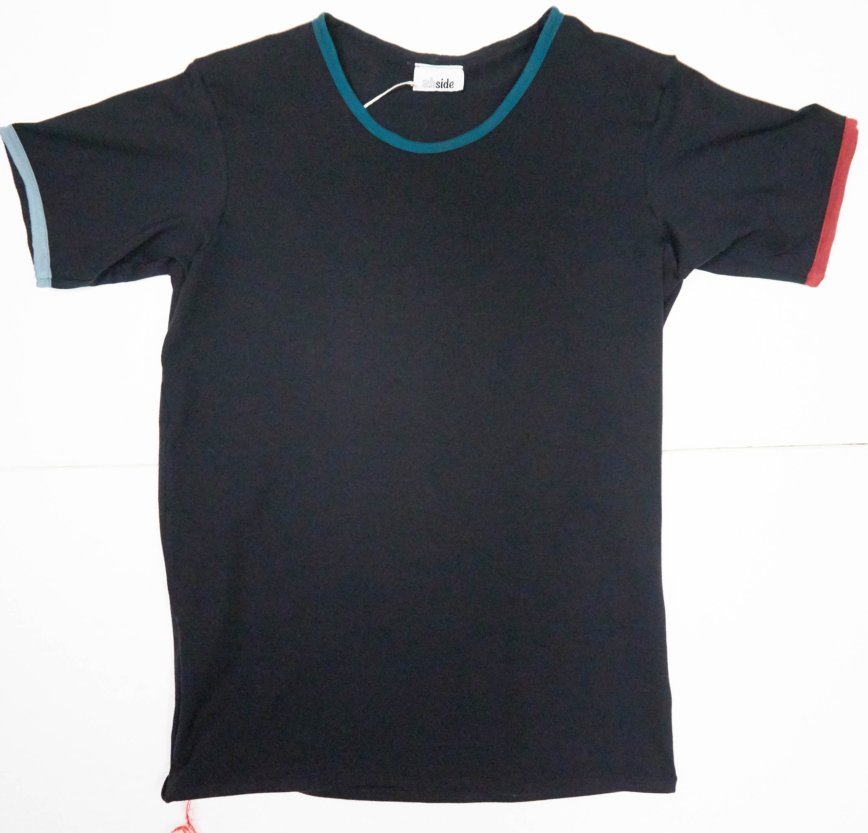 Maglietta in cotone biologico con inserti. Colore nero e inserti rosso, ottanio e azzurro