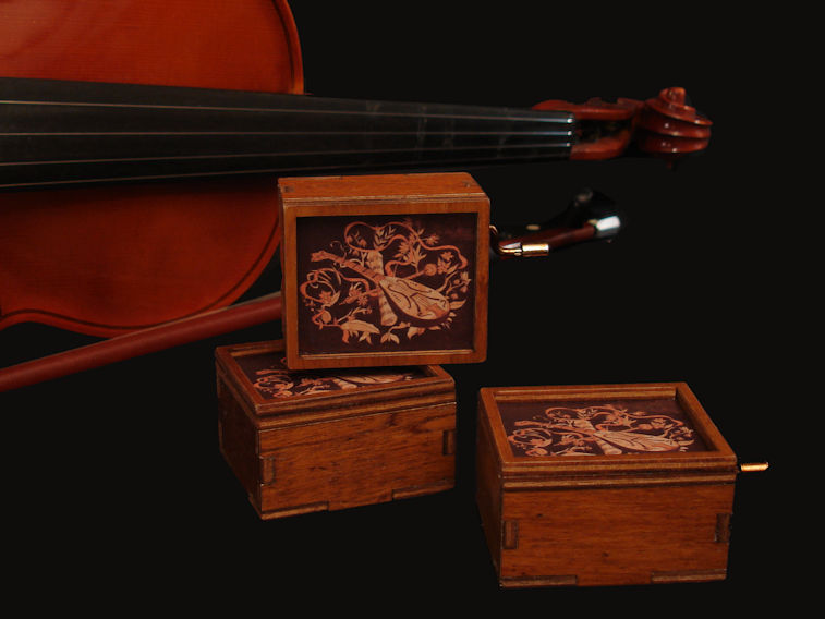 Alcune scatoline musicali di legno invecchiato messe una sull’ altra
