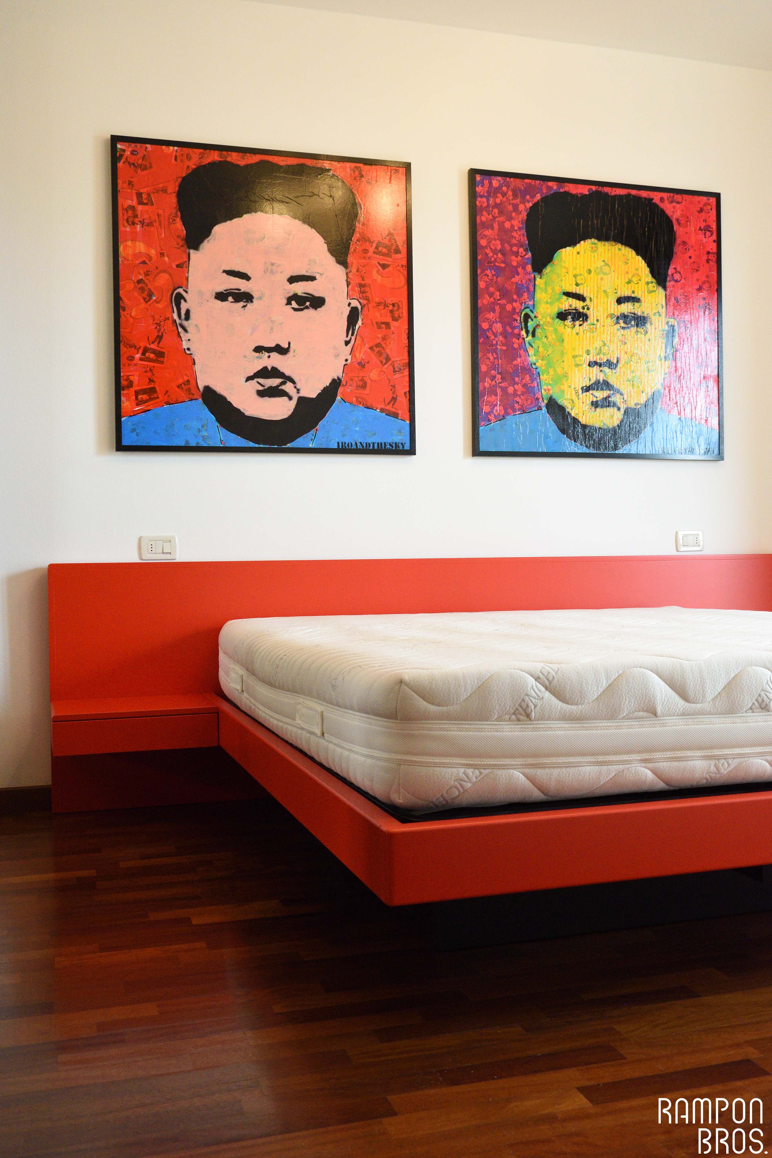 Letto laccato rosso fuoco, quadri d'artista raffiguranti il leader sudcoreano Kim Jong-Un.