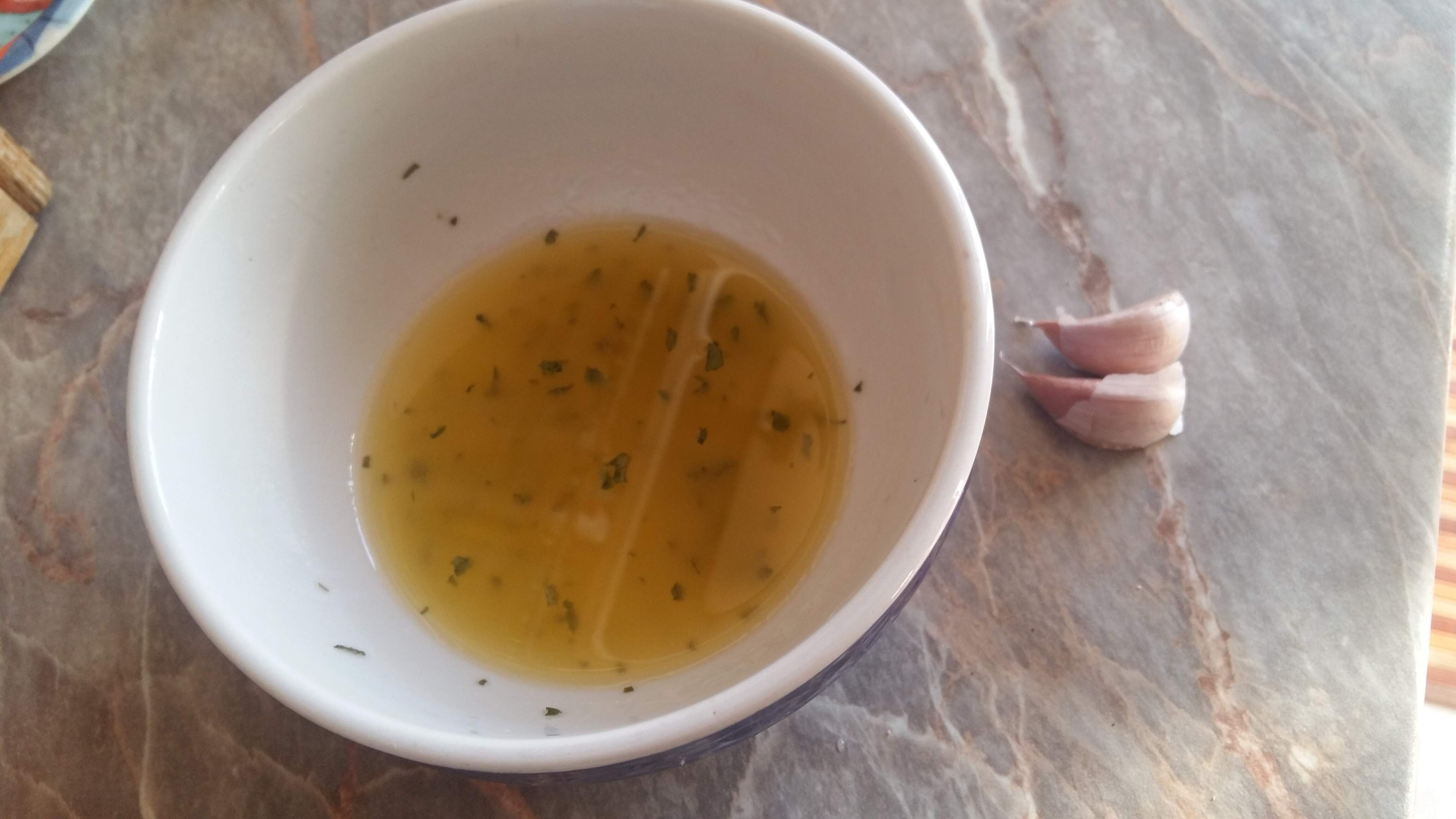 Przygotowujemy oliwe roztrzepana z odrobina octu, soli i przypraw. Sielamy czosnek.