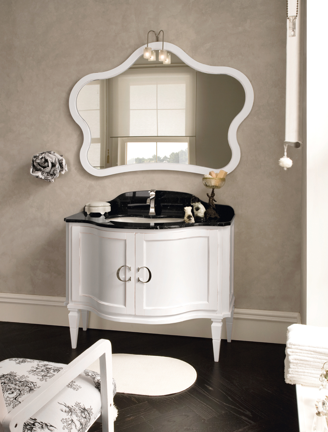 bagno classico raffinato - contrasto fra piano marmo nero e base bianca sagomata - maniglia con logo
