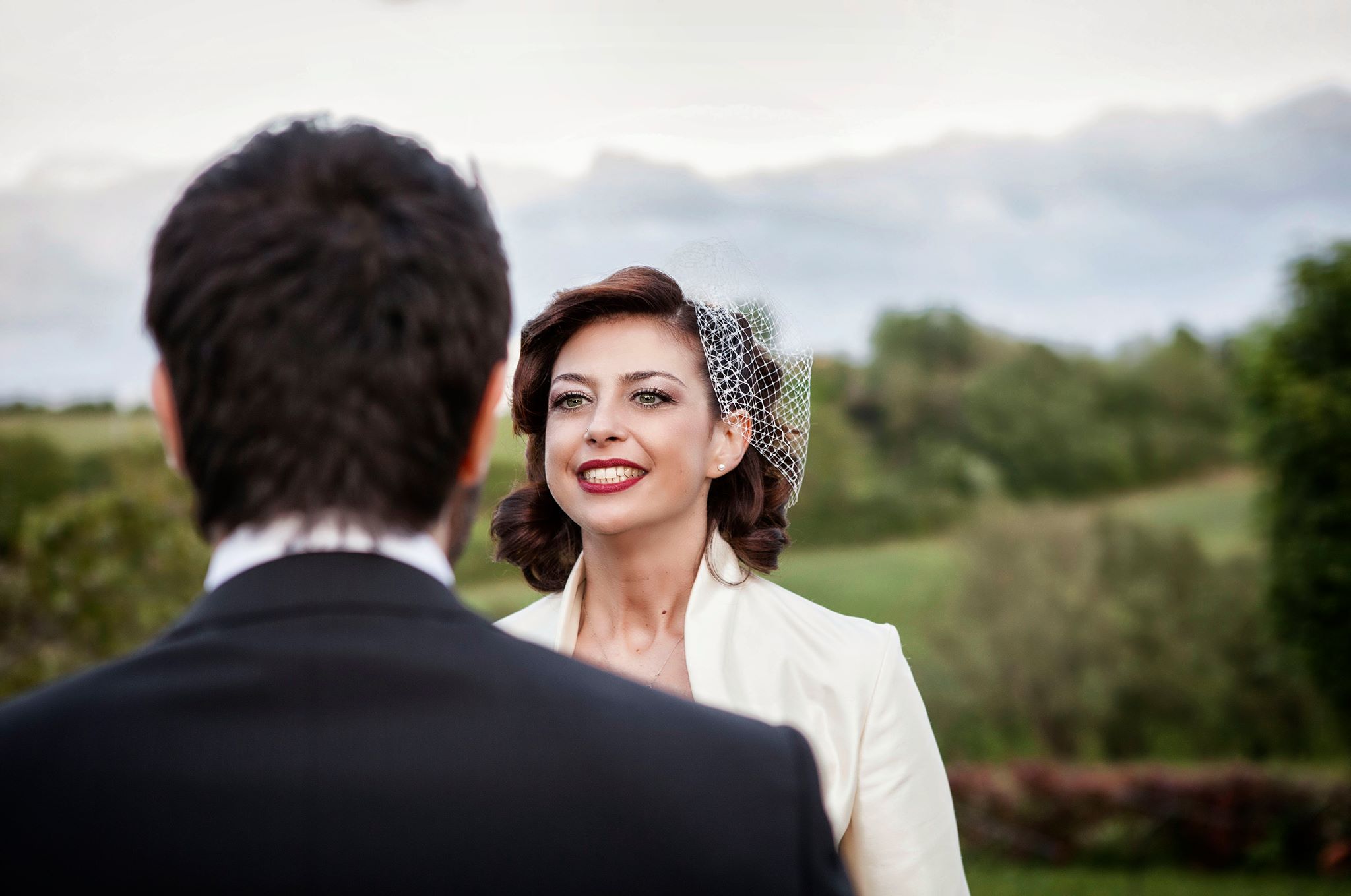 sposa e sposo uno difronte all'altro con sfondo le colline toscane