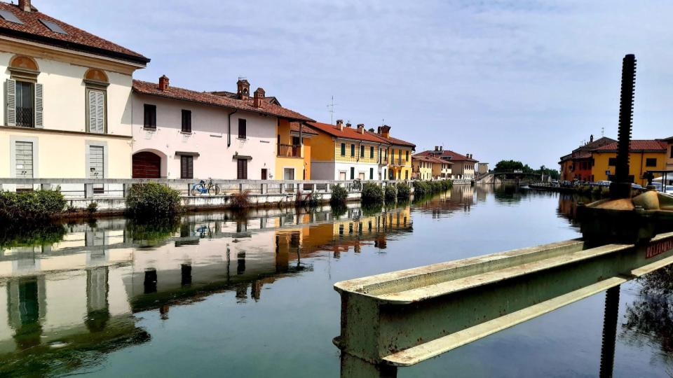 Il borgo di Gaggiano sul naviglio Grande con le sue case basse e colorate che riflettono sulle acque