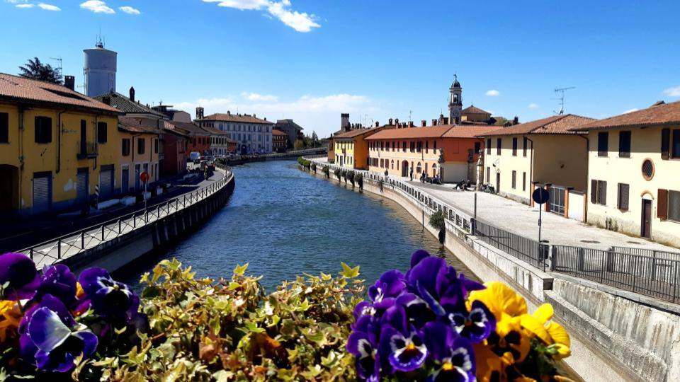 Foto dal ponte vecchio di Gaggiano con fiori con vista sul naviglio Grande verso Abbiategrasso